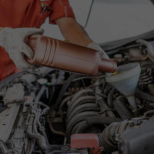 Car mechanic replacing and pouring fresh oil