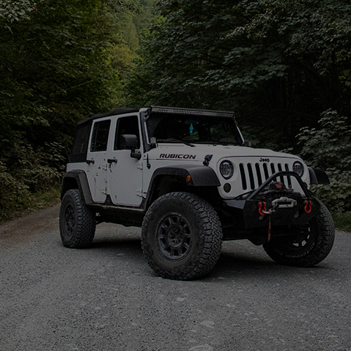 Lifted white Jeep with light bar